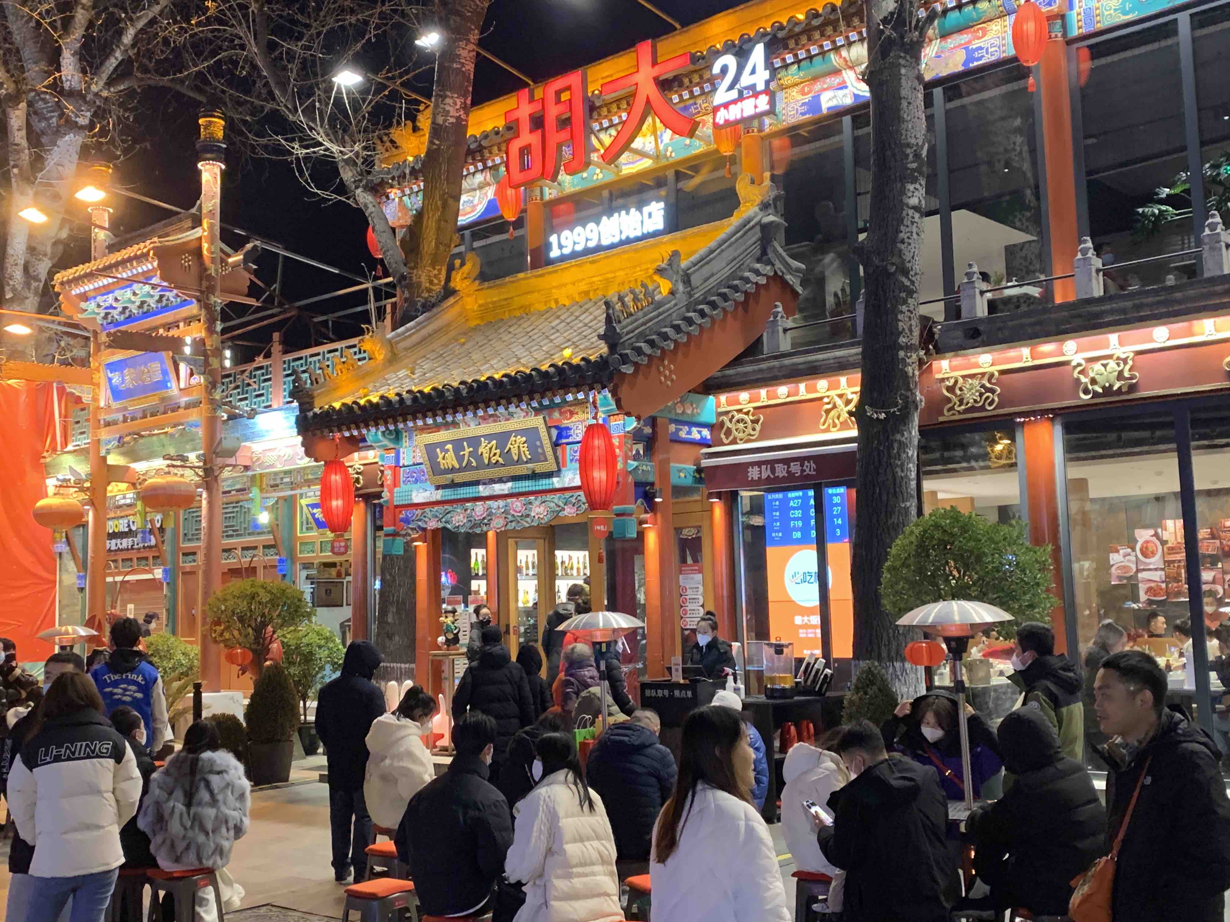 圣诞节周末晚上，北京知名餐厅胡大饭馆外，涌现排队等待品尝小龙虾的饕客 ...